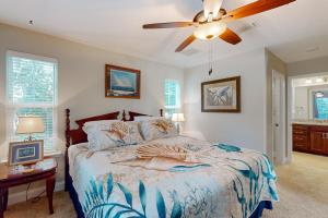 a bedroom with a bed with a ceiling fan at Charming apartment with beautiful marsh views and shared patio in Fernandina Beach