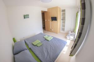 a bedroom with a blue bed with two green pillows at Penzion Tsport in Wotitz