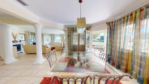 une salle à manger avec une table en verre au milieu dans l'établissement Greenview Villa by ON Travel, à Oliva