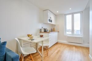eine Küche mit einem Tisch und Stühlen im Zimmer in der Unterkunft Appartement calme vue Château in Versailles