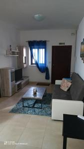 een woonkamer met een bank en een salontafel bij Star Dream Apartment in Xgħajra