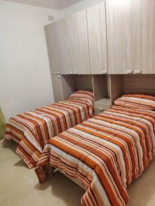 two beds are lined up in a room at Star Dream Apartment in Xgħajra