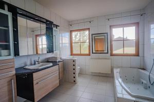 a bathroom with a tub and a sink and a bath tub at Villa mit Pool und Garten in Thalheim bei Wels +12 photos