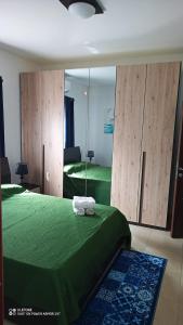 a bedroom with a green bed and a mirror at Star Dream Apartment in Xgħajra
