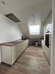 a kitchen with white cabinets and a skylight at En bord de mer, vue et accès direct à la plage in Batz-sur-Mer