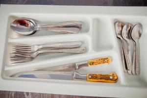 a white tray with silver utensils in it at Babylon Apartments On Soborna in Rivne +6 photos