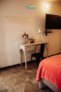 a bedroom with a desk with a bed and a tv at Entrebosques in Santa Elena
