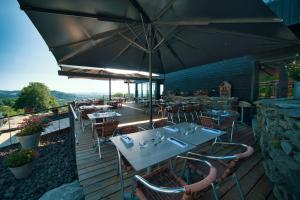 een restaurant met tafels en stoelen en een parasol bij La Ferme du Bien-etre in Saint-Julien-Chapteuil