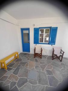 a room with two benches and a blue window at Kouki Maria Rooms in Apollonia
