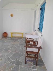 une chambre avec deux chaises, une table et un banc dans l'établissement Kouki Maria Rooms, à Apollonia
