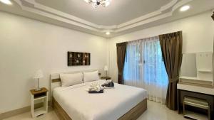 Schlafzimmer mit einem weißen Bett und einem Fenster in der Unterkunft Single Home 2brs2baths Phuket Kathu Townkis in Ban Huai Luk (1)