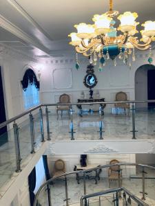 een grote kamer met een kroonluchter en tafels en stoelen bij The Peacock Mansion in Kumasi
