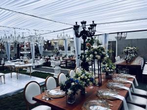 un salón de banquetes con mesas, sillas y flores en The Peacock Mansion, en Kumasi