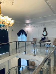 a large room with a staircase and a chandelier at The Peacock Mansion in Kumasi