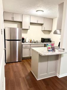 a kitchen with white cabinets and a stainless steel refrigerator at Charming 3BR 1.5BA Cozy Haven in Rome