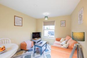 a living room with a couch and a tv at Sheriffs Tower Cottage - East in Bishop Auckland