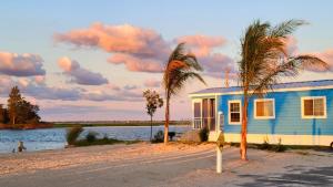 a blue house on a beach with palm trees at Sun Outdoors Rehoboth Bay in Millsboro