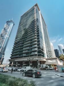 a large building with cars parked in a parking lot at Gorgeous Apt Studio with balcony in Business Bay in Dubai
