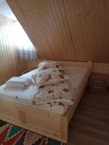 Cama en habitación con techo de madera en Cabana Daria, en Gârda de Sus