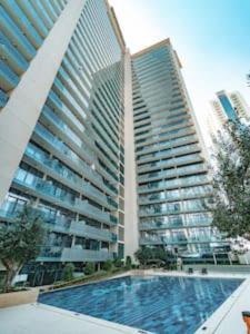 a large building with a swimming pool in front of a building at Gorgeous Apt Studio with balcony in Business Bay in Dubai