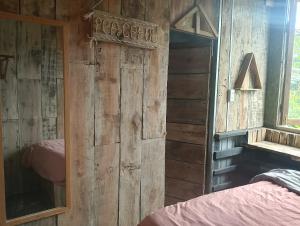 een slaapkamer met een houten wand met een spiegel bij DALAT INN DISCOVERY HOSTEL in Da Lat