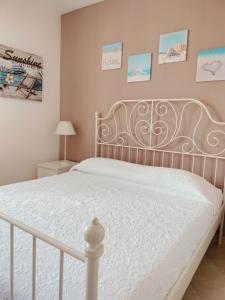 1 cama en un dormitorio con marco de cama blanco en La casa di Ieia, en Porto Ercole