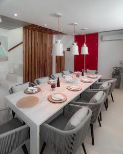 a dining room with a large white table and chairs at Sabbia By LD in El Roque
