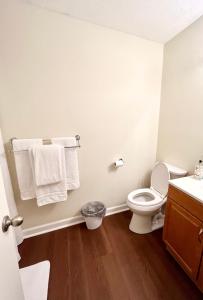 uma casa de banho com WC e toalhas na parede em Charming 3BR 1.5BA Cozy Haven em Rome