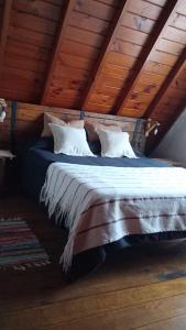 uma cama grande num quarto com tectos em madeira em Cabaña,Chalet Alpino Bosques de Peralta Ramos em Mar del Plata
