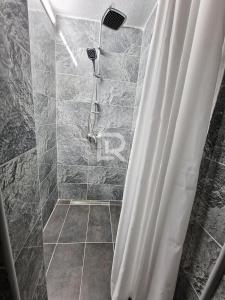 uma casa de banho com chuveiro e cortina de chuveiro em Villa Dalmacija em Prijedor