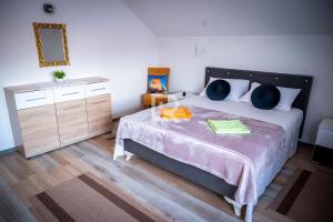 a bedroom with a bed with two blue pillows at Villa Dalmacija in Prijedor