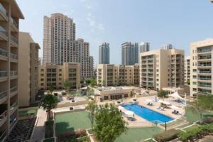 an aerial view of a pool in a city with tall buildings at Unique 1Bedroom with Balcony Greens Dubai in Dubai