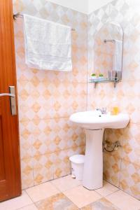 een badkamer met een witte wastafel en een toilet bij Ahva II Residence in Jinja