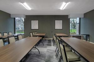 une salle à manger avec des tables et des chaises en bois dans l'établissement Best Western Plus Meadowlands, à Secaucus