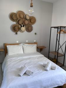 un letto con asciugamani e cappelli appesi al muro di Captain's Studios a Spetses