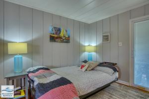 een kleine slaapkamer met een bed en 2 lampen bij Lil' Nauti in Surf City