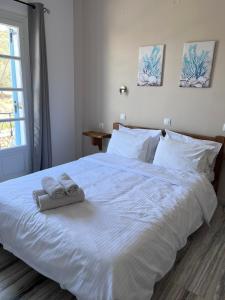 Un dormitorio con una cama blanca con toallas. en Captain's Studios, en Spetses