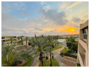 a view of a street with palm trees and a sunset at Malaya suite in Caesarea