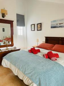 Valle de AbdalagísにあるCasa Los Barberosのベッドルーム1室(大型ベッド1台、赤い枕付)