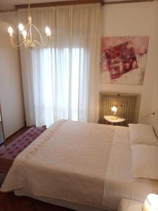 a bedroom with a large white bed and a window at Angela Home in Rimini