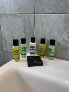 4 botellas de desinfectante sentadas en el lavabo del baño en Captain's Studios, en Spetses