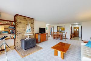 a living room with a brick fireplace and a tv at Port Ludlow Resort Condo 2 in Port Ludlow