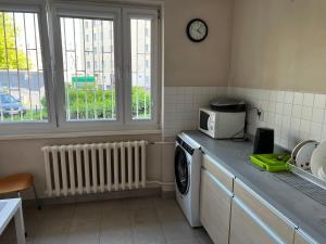 a kitchen with a washing machine and a microwave at Warszawa Zachodnia in Warsaw