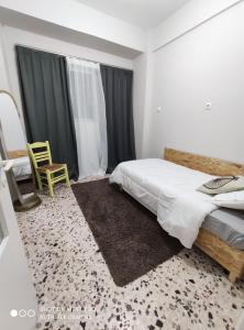 1 dormitorio con 1 cama y 1 silla en anamnesis Agrinio en Agrinio