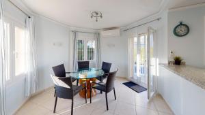 a dining room with a glass table and chairs at Villa Cisne by ON Travel in Casas Devesa