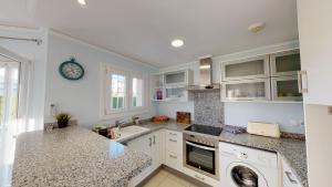 a kitchen with a sink and a washing machine at Villa Cisne by ON Travel in Casas Devesa +6 photos
