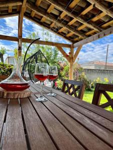 two glasses of red wine sitting on a wooden table at ,,Anna's" Guesthouse in K'vemo Alvani