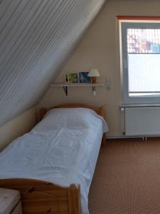 ein kleines Schlafzimmer mit einem Bett im Dachgeschoss in der Unterkunft Ferienhaus Linke in Fuhlendorf