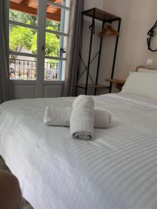 a white bed with two towels on top of it at Captain's Studios in Spetses