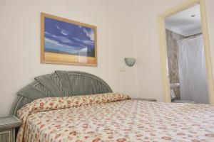 a bedroom with a bed and a picture on the wall at Peony by ON Travel in Oliva +15 photos